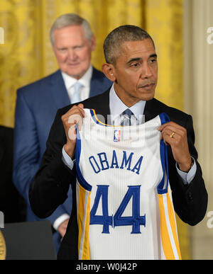 Le président des États-Unis, Barack Obama, est titulaire d'une association à jersey alors qu'il honore les champions NBA 2015 Golden State Warriors dans l'East Room de la Maison Blanche à Washington, DC, le 4 février 2016. Los Angeles Lakers légende Jerry West, qui est un conseiller pour les guerriers, les regarde. Photo de Pat Benic/UPI Banque D'Images