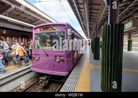 Kyoto, Japon - 11 Nov 2017 : l'identité traditionnelle violet train stationné sur la plate-forme avec des passagers à la station arashiyama Banque D'Images