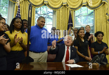 Le président Donald Trump se félicite de la victoire de l'école les enfants de l'École Centre Chrétien de Charlotte (Caroline du Nord, pour le bureau ovale qui ont conçu une fusée lors d'un concours, qu'ils ont appelé 'Trompette', assis sur son bureau (L), à la Maison Blanche, le 12 mai 2017, à Washington, DC. Photo de Mike Theiler/UPI Banque D'Images