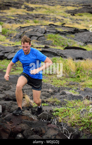 Homme actif sur les roches volcaniques de course sur sentier de montagne en arrière-plan. Faire une course de l'athlète masculin ultra marathon à travers un paysage en Ohio, USA. Banque D'Images