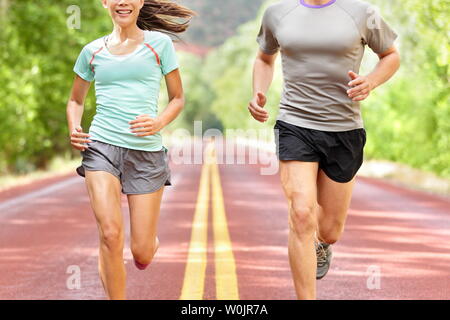La santé et la forme physique d'exécution. Coureurs sur exécuter la formation au cours d'entraînement de forme physique à l'extérieur sur la route. Les personnes vivant ensemble jogging mode de vie sain et actif à l'extérieur en été. Portrait de femme et l'homme. Banque D'Images