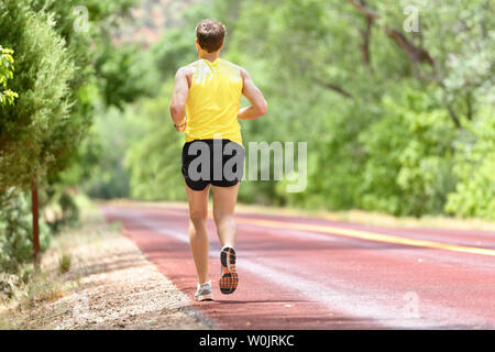 Running Man jogging runner pour le fitness et la santé. Athlète masculin sur l'élaboration d'exécuter sur le port de chaussures de sport et des courts-circuits dans l'entraînement pour le marathon. La pleine longueur du corps vue montrant l'arrière de s'enfuir. Banque D'Images