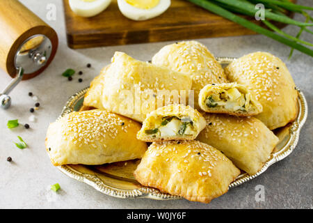 La cuisine russe traditionnelle. Oeufs tartes et les oignons verts sur la lumière table en pierre. Banque D'Images