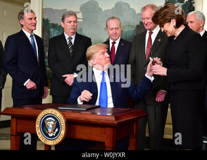 Le président Donald Trump, Marillyn Hewson, PDG de Lockheed Martin, un stylo après la signature d'un ciblage de la note de la Chine sur le commerce dans le à la Maison Blanche le 22 mars 2018. Mémorandum du président Trump vise à réprimer tout ce qu'il appelle les "pratiques commerciales déloyales" sur les pratiques économiques chinois et la mise en place de la possibilité des droits de douane et restrictions d'investissement. Photo par Kevin Dietsch/UPI Banque D'Images