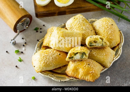 La cuisine russe traditionnelle. Oeufs tartes et les oignons verts sur la lumière table en pierre. Banque D'Images