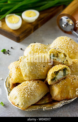 La cuisine russe traditionnelle. Oeufs tartes et les oignons verts sur la lumière table en pierre. Banque D'Images