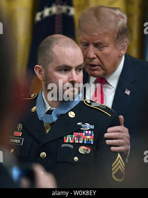 Le président Donald Trump whispers to Combat Forces Spéciales medic Ronald J. Shurer après remise de la médaille d'honneur, à la Maison Blanche, le 1 octobre 2018, à Washington, DC. L'US Army Sgt. médical avaient tendance à blessés et aidé aux évacuations, sauver de nombreuses vies des troupes, au cours d'un échange de feu en Afghanistan en avril 2008. Photo de Mike Theiler/UPI Banque D'Images