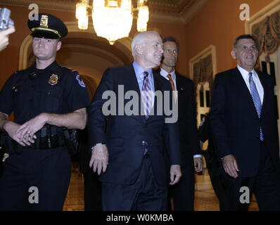 Candidat présidentiel républicain le sénateur John McCain (R-AZ) (2L) promenades avec le sénateur John Thune (R-SD) (R) dans la chambre du Sénat sur la colline du Capitole à Washington le 1er octobre 2008. Le Sénat s'est réunie pour une séance en soirée et adopté le plan de sauvetage de 700 milliards de dollars de l'industrie financière. (Photo d'UPI/Yuri Gripas) Banque D'Images