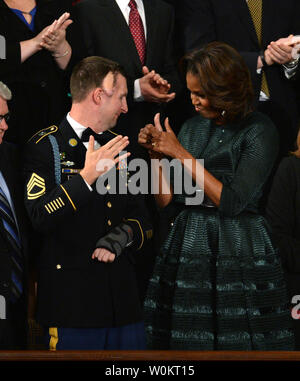 La Première Dame Michelle Obama donne le feu vert à l'Armée de première classe sergent des Rangers Remsburg Cory, qui a été blessé en service en Afghanistan, qu'ils auront reçu une ovation debout avant l'arrivée du Président Barack Obama pour son état de l'Union dans la chambre Chambre à la capitale américaine le 28 janvier 2014 à Washington, DC. UPI/Pat Benic Banque D'Images