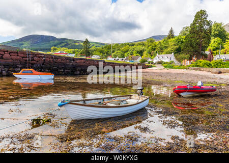 Petit port à Corrie sur l'île d'Arran, Firth of Clyde, en Écosse avec trois petits bateaux au bord de l'eau. Banque D'Images