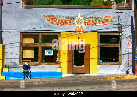 Homme assis à l'extérieur de la carrière bar restaurant brasserie sur signalisation Ave dans la ville historique de Bisbee, AZ Banque D'Images