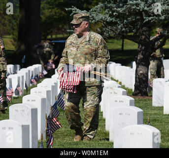 Ses quatre étoiles Le Général Mark Milley lieux drapeaux devant de tombe au cimetière national d'Arlington au cours de la 'tradition' dans les drapeaux à Arlington, en Virginie, le 24 mai 2018. Milley est 39e Chef d'état-major de l'armée et le plus haut responsable militaire dans le l'armée. Le 3e Régiment d'infanterie américaine (la vieille garde) a honoré les anciens combattants pour plus de 60 années en plaçant les drapeaux de leurs tombes. Photo de Pat Benic/UPI Banque D'Images