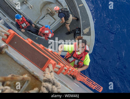 2222 Fuiaba, une Américaine mariner qui navigue depuis 5 mois sur un voilier endommagé, grimpe dans l'échelle de coupée à bord du navire de débarquement amphibie USS Ashland dock (LSD 48) le 25 octobre 2017. Ashland, opérant dans la région du Pacifique-Indo-Asia sur un déploiement de routine, a secouru deux marins américains qui avaient été en détresse pendant plusieurs mois après leur voilier a eu une panne de moteur et s'était égarée et de son parcours d'origine en traversant l'océan Pacifique. Photo par MC3 Jonathan Clay/U.S. Navy/UPI. Banque D'Images