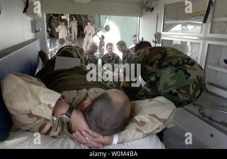 Les membres de l'US Air Force expéditionnaire du 491st escadron de l'évacuation de l'air et la flotte de la Marine américaine jusqu'à l'équipe de l'hôpital huit blessés charge avec soin les membres de service dans une ambulance à la base navale de Rota en Espagne le 2 avril 2003. La Force aérienne un avion cargo C-5 Galaxy transporté 21 blessés l'Opération Liberté pour l'Irak du Koweït à Rota pour le traitement à l'hôpital de campagne. Histoire d'aller avec BC-US-IRAK-victimes. (UPI/U.S. DAN MARINE/SMITHYMAN) Banque D'Images