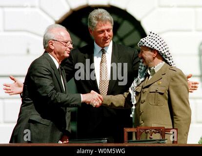 Le dirigeant palestinien Yasser Arafat indiqué sur cette photo est mort dans un hôpital militaire à l'extérieur de Paris dès le 11 novembre 2004. Il était âgé de 75 ans. La photo montre le président Clinton à la recherche sur le Premier Ministre israélien Rabin et Yirzhak l'Organisation de libération palestinienne, Yasser Arafat, chef de la poignée change après la signature du Traité de paix israélo-arabe, le 13 septembre 1997 lors d'une cérémonie à la Maison Blanche. (Photo d'UPI/Leighton Mark) Banque D'Images