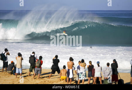 Manèges d'un surfer une vague massive lors d'un warm up pour le Rip Curl Pro Pipeline masters à l'Banzai pipeline sur la côte nord d'Oahu, Hawaii le 13 décembre 2004.. Le concours a été mis en attente en raison de conditions de surf de tempête qui a frappé la Côte-Nord. Le Rip Curl Pipeline masters est l'événement final pour les hommes sur la 2004 favorise l'ASP World Championship Tour et offre le top 45 surfeurs et trois wild card entrants. (Photo Pierre Tostee/UPI/ASP Tostee) Banque D'Images