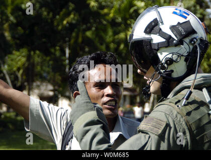 Les systèmes de guerre Aviation 2e classe opérateur Justin Garrett de Burbank, Californie, des entretiens avec un représentant local dans la ville de Lamno, Sumatra sur ce que l'aide de secours est nécessaire le 7 janvier 2005. Porte-hélicoptères affectés à deux de l'Escadre aérienne (CVW-2) et les marins de l'USS ABRAHAM LINCOLN (CVN 72) appuient l'opération Unified Assistance, l'opération humanitaire d'efforts à la suite du tsunami qui a frappé l'Asie du Sud Est. (Photo d'UPI/Seth C. Peterson/US Navy) Banque D'Images