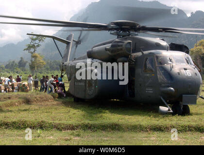 Les Indonésiens dans la ville de Sabang à Pulau Nous, décharger la nourriture, les vêtements et les fournitures de secours à l'arrière d'un MH-53E Sea Dragon hélicoptère, affecté à l'hélicoptère des Blackhawks' 'la lutte contre les mines 15 Escadron (HM-15) le 23 janvier 2005. (Photo d'UPI/Travis M. Burns/Navy) Banque D'Images