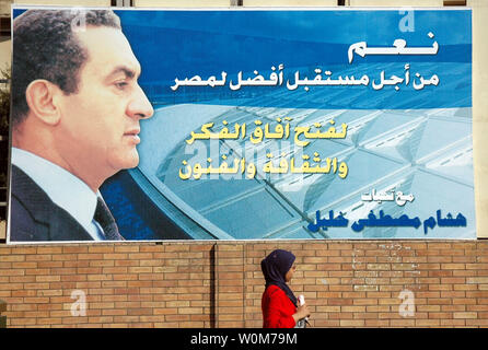 Citoyen vit en face d'une campagne électorale affiche pour titulaire le président égyptien Hosni Moubarak au Caire le 31 août 2005. Sous-titre suivant : "Oui pour un meilleur avenir pour l'Egypte." La majorité des affiches de campagne et bannières qui apparaissent sur Le Caire sont placés par les partisans du Président sortant comme un acte de loyauté et de démontrer leur soutien à lui au cours des prochaines élections présidentielles le 7 septembre 2005. (Photo d'UPI/Stewart Innes) Banque D'Images