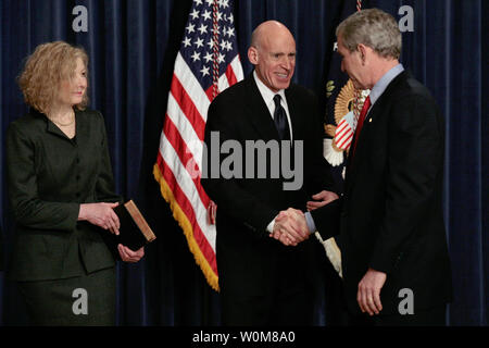 Le Président George Bush serre la main de nouveau prêté serment Eddie Lazear comme président du Conseil des Conseillers économiques à la EEOB à Washington DC le 6 mars 2006. L'épouse de Lazear Vicki montres. (Photo d'UPI/Ken Cedeno) Banque D'Images