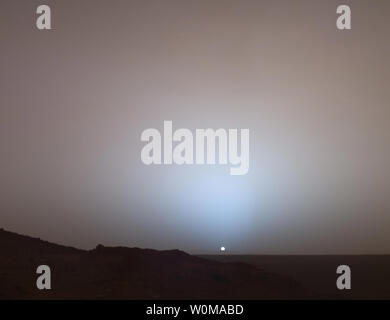 Mars Exploration Rover de la NASA a capturé l'esprit de ce point de vue : le soleil se couche au-dessous du bord de cratère de Gusev sur Mars le 19 mai 2005. Cette caméra panoramique (Pancam) mosaïque a été prise vers 6:07 le soir du rover 489th jour martien. Ce petit panorama du ciel de l'ouest a été obtenu à l'aide de 750 nanomètres Pancam, 530 nanomètres et 430 nanomètres de filtres de couleur. Ce filtre permet la combinaison des images en fausses couleurs d'être générés qui sont similaires à ce qu'un humain verrait. Banque D'Images