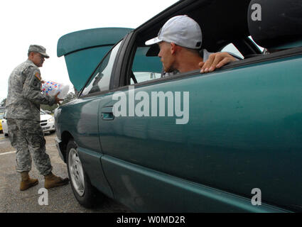 De retour d'une personne évacuée Gulfport, Mississippi observe alors que la CPS. de l'Armée David Kennedy, de la Garde nationale de l'Armée du Mississippi, les lieux d'un sac de glace dans sa voiture à un point de distribution à l'extérieur de Gulfport le 2 septembre 2008. Les citoyens ont commencé à rentrer hier après l'ouragan Gustav à l'évacuation des forces de la région. (Photo d'UPI/Michael J. Carden/DOD) Banque D'Images