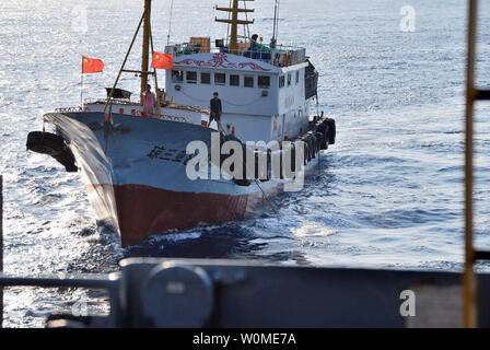 Un membre d'équipage d'un chalutier chinois utilise un crochet pince dans une tentative apparente pour accrocher le réseau acoustique remorqué du transport maritime militaire de surveillance océanique commande ship USNS impeccable (T-AGOS-23) dans la mer de Chine du Sud le 8 mars 2009. La réalisation a été impeccable des opérations des enquêtes de routine dans les eaux internationales à 75 miles au sud de l'île de Hainan lorsqu'il a été harcelé par cinq bateaux chinois. (Photo d'UPI/U.S. Marine) Banque D'Images