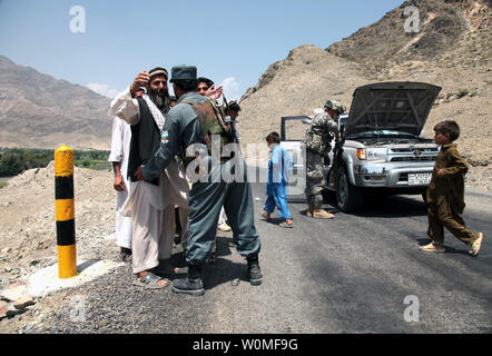 Nationale Afghane un policier et un soldat de l'armée américaine recherchez un véhicule et ses passagers à une inspection de contrôle près de la base d'opération avancée Joyce, Konar province, Afghanistan, le 11 août 2009. Les forces de sécurité nationale afghanes et les soldats de l'armée des États-Unis travaillent de concert pour fournir une sécurité avant l'élection présidentielle afghane prévue pour le 20 août. UPI/Andrew Smith/U.S. Army Banque D'Images