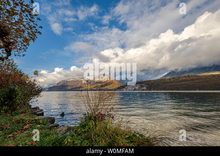 Un temps magnifique vue depuis un angle bas sur le lac d'Annecy, France, avec des montagnes avec des nuages bas à l'arrière-plan Banque D'Images