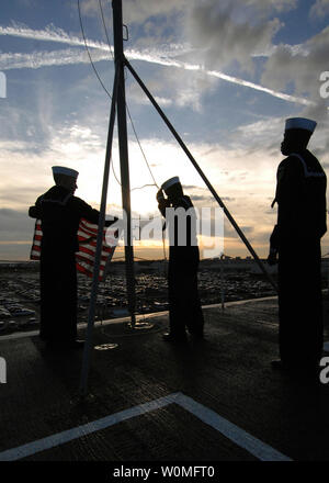 Les marins affectés à la classe Nimitz porte-avions USS Harry S. Truman pour saluer le drapeau américain au cours de matin de couleurs. UPI/Donald R. White Jr./U.S. Navy Banque D'Images