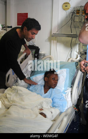 Le Dr Sanjay Gupta examine une jeune Haïtienne blessés dans le centre médical à bord de la classe Nimitz sous porte-avions USS Carl Vinson (CVN 70) près de Port-au-Prince, Haïti, le 18 janvier 2010. Gupta, un neurochirurgien et reporter pour le CNN News Network, a été portée à l'expédier pour les aider à effectuer une chirurgie du cerveau sur un 12-year-old fille Hatian. UPI/Erin Oberholtzer/U.S. Navy Banque D'Images