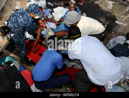 Maître de 2e classe Jonathan Sanders (L) et d'autres travailleurs de l'aide aider à déplacer un enfant à une civière pour le transport vers une zone d'attente d'évacuation médicale en Killick, Haïti le 19 janvier 2010. Les unités de toutes les branches de l'armée américaine mènent des opérations de secours en cas de catastrophe humanitaire et dans le cadre de l'opération réponse unifiée après un séisme de magnitude 7,0 a ravagé Haïti le 12 janvier. UPI/Curaron Martine/U.S. Marine. Banque D'Images