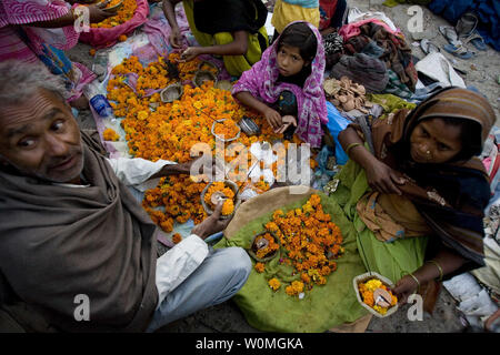 Une famille indienne vend des fleurs et de lampes utilisées pour le culte au cours de la fête de Kumbha Mela à Haridwar, Inde le 14 avril 2010. Le pèlerinage a lieu tous les trois ans, la rotation entre les quatre différents endroits en Inde, donc, une fois tous les 12 ans dans chaque lieu. Il dure 42 jours d'attirer des millions de personnes, et cette année se termine le 28 avril 2010. Les dévots croient que prendre un bain dans la rivière se laver leurs péchés afin qu'ils commencent une nouvelle vie. Maryam Rahmanian/UPI Banque D'Images