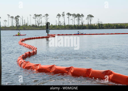 Les kayakistes à la Naval Air Station Pensacola en Floride flotter autour d'un barrage de rétention des hydrocarbures à Sherman Cove le 4 mai 2010. Le boom a été défini pour protéger les herbiers écologiquement sensibles provenant de la marée noire après la plate-forme pétrolière Deepwater Horizon a coulé le 22 avril après une explosion, provoquant une marée noire menace la côte américaine du golfe du Mexique. UPI/Patrick Nichols/U.S. Navy Banque D'Images