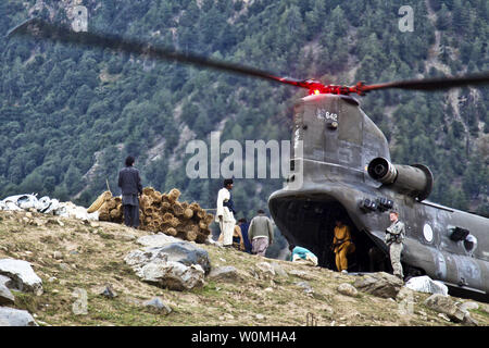 Décharger les hommes pakistanais construction fournitures par un hélicoptère CH-47 Chinook de l'Armée à partir de la 16e Brigade d'aviation de combat pour reconstruire des maisons dans Matlatan les victimes des inondations au Pakistan, le 28 septembre. Jason/UPI/Bushong US ARMY Banque D'Images