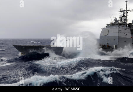 Au cours de la pause des vagues de classe Ticonderoga croiseur lance-missiles USS Bunker Hill (CG 52) comme le navire reçoit le carburant de la classe Nimitz porte-avions USS Carl Vinson (CVN 70) lors d'un ravitaillement en mer le 24 décembre 2011. Carl Vinson et Carrier Air Wing (CVW) 17 sont en cours d'un déploiement de l'ouest du Pacifique. UPI/Dean M. Cates/marine. Banque D'Images