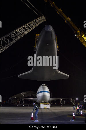 Navette spatiale Enterprise est tenue en altitude par une écharpe jaune et un ensemble de grues après qu'il a été retiré de la partie supérieure de la NASA Navette 747 avions de transport aérien tôt dimanche matin à l'aéroport John F. Kennedy (JFK) de l'Aéroport International de New York le 13 mai 2012 .Le 747 a été remorqué en arrière de sorte que l'entreprise pourrait être réduit. La navette sera placé sur une barge qui se déplace par le remorqueur Hudson River à l'Intrepid Sea, Air & Space Museum en juin. La navette sera levé par une grue et placés sur le pont de l'Intrépide, où il sera exposé au public dès cet été dans un temp Banque D'Images