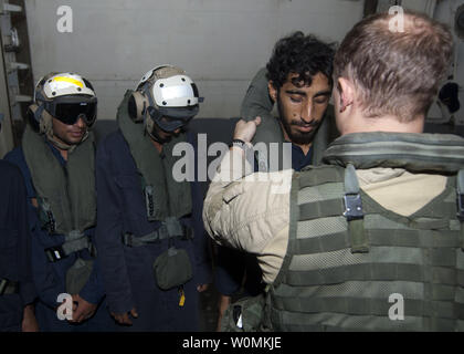 Les marins affectés à missiles de l'USS James E. Williams (DDG 95) charger a sauvé les marins iraniens sur la façon de porter un équipement de protection avant d'être transporté par hélicoptère vers le porte-avions USS Enterprise (CVN 65), dans le golfe d'Oman, le 9 août 2012. Dix marins iraniens ont été secourus après qu'ils ont été forcés d'abandonner leur navire, qui a pris feu dans le golfe d'Oman. Daniel Meshel/UPI/US Navy. Banque D'Images