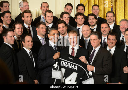 Le président des États-Unis, Barack Obama détient des Kings de Los Angeles autographié avec dvd Dustin Brown pendant l'Est au cours d'une cérémonie à la Chambre des joueurs et entraîneurs de la Major League Soccer (MLS) champions LA Galaxy et le Los Angeles Ligue nationale de hockey (LNH) champions des Kings de Los Angeles à la Maison Blanche à Washington, DC Le 26 mars 2013. UPI/Pat Benic Banque D'Images