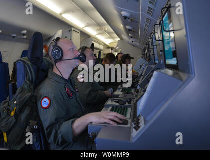 Les membres d'équipage à bord d'un P-8A Poseidon affectés à l'Escadron de patrouille (VP) 16 homme leurs postes de travail tout en aidant aux opérations de recherche et sauvetage pour du vol MH370 de Malaysia Airlines, sur l'Océan Indien, le 16 mars 2014. La zone de recherche a été élargi après une semaine longue recherche dans la mer de Chine n'a pas réussi à produire des résultats. UPI/Eric A. Pasteur/US Navy Banque D'Images