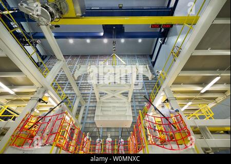 Une grue dans une chambre propre à la NASA Goddard Space Flight Center à Greenbelt, Maryland, réduit une masse inconnue simulator (centre du châssis) sur l'ensemble optique ambiant Stand ou AOAS pendant l'essai le 7 août 2013 pour s'assurer qu'il peut appuyer le télescope spatial James Webb télescope optique de l'élément lors de son assemblée. Le Télescope Spatial James Webb est le successeur de scientifiques du Télescope spatial Hubble de la NASA. Il sera le plus puissant télescope spatial jamais construit. Webb est un projet international mené par la NASA, en collaboration avec ses partenaires, l'ESA (Agence Spatiale Européenne) et l'Agence spatiale canadienne. NASA Banque D'Images