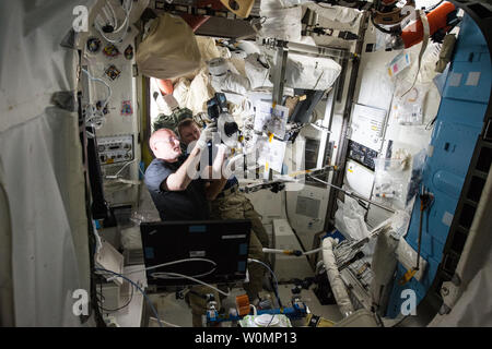 L'astronaute de la NASA Scott Kelly (à gauche) et l'ESA (Agence Spatiale Européenne) astronaut Timothy Peake (droite) des images au cours d'une 10 janvier 2016 procédure pour remplacer une pompe de ventilateur à l'intérieur du séparateur d'une des combinaisons spatiales américaines à bord de la Station spatiale internationale. L'activité a eu lieu à l'intérieur du sas Quest où toutes les sorties dans l'américain begin et end. NASA/UPI Banque D'Images