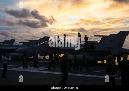 Les marins sont sur un F/A-18F Super Hornet à bord du USS Ronald Reagan (CVN 76) pour obtenir une meilleure vue de l'artifice au cours de la célébration de la Journée de l'indépendance du navire le 4 juillet 2016, en mer de Chine du Sud. Ronald Reagan, le groupe aéronaval du cinq (5) CSG, phare est en patrouille dans la 7e Flotte des États-Unis à l'appui de la zone de responsabilité de la sécurité et de la stabilité dans la région du Pacifique-Indo-Asia. Photo de James Mullen/U.S. Navy/UPI Banque D'Images