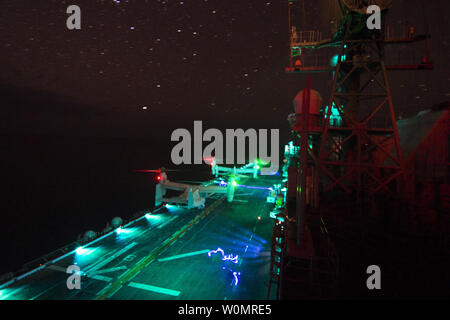 MV-22 Ospreys affecté à la crête de glissières de support Marine Escadron à rotors basculants (VMM) 163 (renforcée), le dispositif de vision nocturne de la conduite des opérations de vol à bord du navire d'assaut amphibie USS Makin Island (DG 8) le 18 décembre 2016. Makin Island est déployée dans le cadre de l'île de Makin Groupe amphibie de la 5e flotte américaine zone des opérations pour appuyer les opérations de sécurité maritime et les efforts de coopération en matière de sécurité dans le théâtre. Photo par Devin M. Langer/U.S. Navy/UPI Banque D'Images