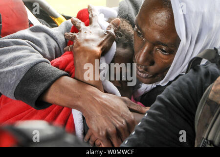 Une femme d'un enfant de la dorlote cabine d'un HH-60 Pave Hawk helicopter, exploité par les aviateurs de la 106e Escadre de sauvetage assigné à la Garde nationale aérienne de New York, plus de Beaumont, au Texas, le 30 août 2017. Les membres du 106e tiré de la famille jusqu'à partir de la crue des eaux en face de leur maison et les ont chuté en toute sécurité à une personne évacuée du point de collecte. Daniel H. Farrell/U.S. Air National Guard/UPI Banque D'Images