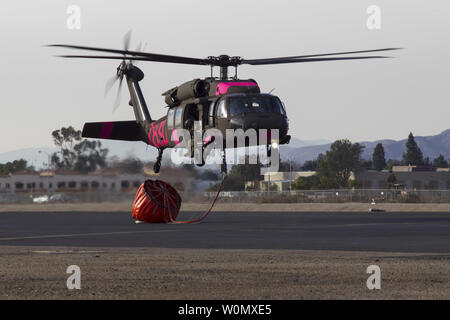 Un UH-60 Black Hawk de l'Armée de la Garde nationale de Californie la Compagnie B, 1er Bataillon, 140e Régiment d'aviation, des terres pour faire le plein à l'aéroport de Camarillo de Camarillo, Californie, le 9 décembre 2017. Les hélicoptères ont passé la journée à l'abandon de l'eau sur le feu Thomas, en coordination avec le feu. Par Thomas samedi soir, le feu a brûlé 173 000 hectares et détruit plus de 500 depuis le début de ses structures le 4 décembre. Photo par SrA Housman Crystal/U.S. Air National Guard/UPI Banque D'Images