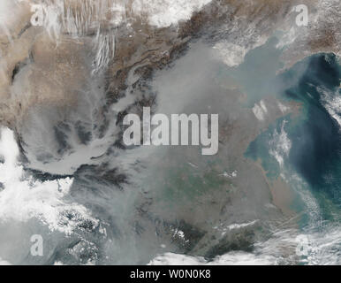 Sur certains jours brumeux, surtout en hiver, le ciel est recouvert par des nuages gris et blanc de polluants atmosphériques. De nouvelles recherches montrent que non seulement le smog tels la diminue dans la lumière du jour et rend l'air difficile à respirer, mais il réduit la quantité de lumière solaire qui atteint les panneaux solaires de la Chine. L'image en couleurs naturelles ci-dessus montre la brume épaisse sur l'est de la Chine le 25 janvier 2017, tel qu'observé par le radiomètre imageur infrarouge visible Suite (VIIRS) sur le satellite NPP Suomi. Le smog gris laiteux, de nombreuses couvertures des vallées et plaines. Les gaz atmosphériques et les polluants sont piégés près de la surface dans les bassins et les Banque D'Images