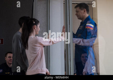 Expedition 58 commandant de Soyouz Oleg Kononenko de Roscosmos, droite, qui est en quarantaine, pose sa main jusqu'à la vitre pour rencontrer sa fille à l'issue d'une conférence de presse, le 2 décembre 2018, à l'hôtel cosmonaute à Baïkonour, au Kazakhstan. Lancement de la fusée Soyouz est prévue pour le 3 décembre et se poursuivra Kononenko, ingénieur de vol de la NASA, Anne McClain et ingénieur de vol David Saint-Jacques de l'Agence spatiale canadienne (ASC) en orbite pour servir pendant six mois et demi de mission sur la Station spatiale internationale. Photo de la NASA par Aubrey Gemignani/UPI Banque D'Images