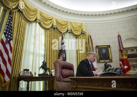 Le président Donald Trump fait un appel vidéo pour les membres en service de l'Armée, Marine Corps, la marine, la Force aérienne et de la garde côtière en poste dans le monde entier depuis le bureau ovale à la Maison Blanche, à Washington, D.C. le 25 décembre 2018. Photo par Zach Gibson/UPI Banque D'Images