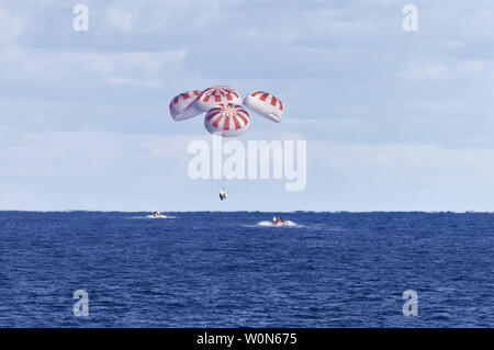 L'équipage SpaceX Dragon est guidé par quatre parachutes à l'approche de splashdown dans l'océan Atlantique à environ 300 kilomètres au large de la côte est de la Floride le 8 mars 2019, après son retour de la Station spatiale internationale sur la Démo-1 mission. Il s'est amarré au laboratoire en orbite le 3 mars, à la suite d'un 2:49 HNE le décollage à bord d'une fusée Falcon 9 de SpaceX complexe de lancement 39A au Centre spatial Kennedy en Floride le 2 mars. Dragon de l'équipage a fait 18 fois le tour de la terre avant de fixation avec succès à la station spatiale. Le satellite de la station à 2 h 32, le 8 mars, la projection vers le bas je Banque D'Images